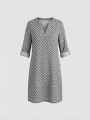 Gray and white patterned mini dress with split-neck and rolled 3/4 sleeves, front view.