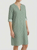 Green and white patterned mini dress with rolled 3/4 sleeves and split-neck, front view.