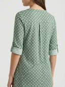 Green patterned mini dress with rolled 3/4 sleeves and back pleats, back view.