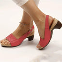Red peep-toe slingback sandals with cork block heel and open toe, angled side view on neutral background.