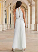 White pleated halter neck jumpsuit with wide legs, back view in an arched hallway.
