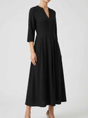 Black maxi dress with V-neck, 3/4 sleeves, and pleated skirt, angled front view on white background.