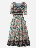 Floral tiered mini dress with short sleeves and a dark blue bodice, front view on a white background.