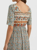 Back view of bohemian tiered mini dress with floral print, elastic waist, and scoop back.