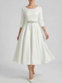 White boat neck midi dress with embellished waist, front view on a light background.