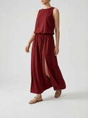 Red sleeveless maxi dress with elastic waist and side slit, angled front view.