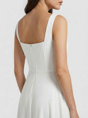 White square-neck A-line mini dress with back zipper detail, angled back view.