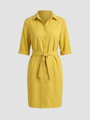 Yellow mini shirt dress with collar, buttons, tied waist, and rolled sleeves, front view.