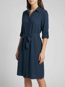 Long sleeve mini dress with button front, tie waist, and rolled sleeves, angled front view.