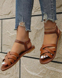 White multi-strap flat sandals with elasticated ankle loop and open toe, front-angle view showing criss-cross strap detail.