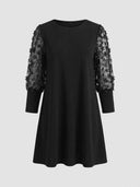 Black mini dress with sheer floral embroidered puff sleeves, front view on gray background.
