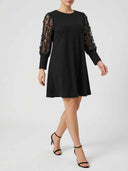 Black mini dress with sheer, sequined long sleeves, angled front view.
