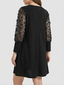 Black mini dress with sheer floral sequin sleeves, back view.