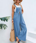 Blue flared jumpsuit with button straps and pockets, angled front view.