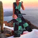 Green and black geometric print maxi dress with deep V-neck, angled view on cliffside.