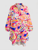 White mini dress with colorful abstract print, button-down front, and high-low hem, front view.