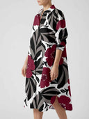White mini dress with large burgundy, black, and gray floral print, angled view.