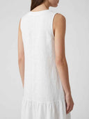 White sleeveless mini dress with ruffled hem, back view on a light background.