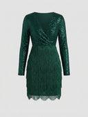 Green sequin mini dress with long sleeves and fringe skirt, front view on white background.
