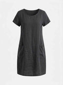 Charcoal linen mini dress with short sleeves and two front pockets, front view.