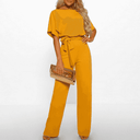 Mustard wide-leg jumpsuit with short sleeves and waist tie, front view on white background.
