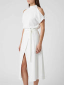 White halter neck dress with shoulder cutouts, side tie, and thigh slit, angled view.