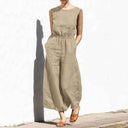 Khaki cotton-linen jumpsuit with relaxed crew neck, elastic waist, and pockets, front view.