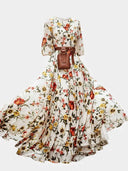 White floral maxi dress with lantern sleeves, brown belt, and pouch, front view.