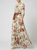 White floral maxi dress with lantern sleeves and brown belt, angled view on white background.