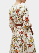 White floral maxi dress with lantern sleeves and brown belt, back view.