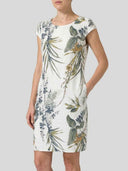 White mini dress with green and blue botanical print, front view.