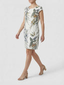 White crew neck mini dress with green and blue botanical print, angled side view.
