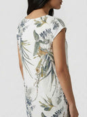 White mini dress with green and brown botanical print, back angled view.