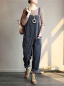 Dark gray velvet wide-leg overall with front pockets, worn over a brown shirt, front view.