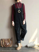 Black velvet wide-leg overalls with front pockets, worn over a maroon turtleneck, front view.