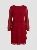 Red long-sleeve mini dress with tiered ruffles and sheer sleeves on a white background, front view.