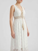 White lace maxi dress with beige trim and tassels, angled view.