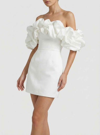 White off-shoulder mini dress with voluminous ruffles, front angled view on white background.