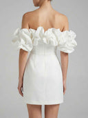 White off-shoulder mini dress with ruffled sleeves, back view on a gray background.