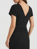 Black V-neck midi dress with ruched back detail and zipper, angled back view.