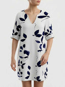 White V-neck mini dress with navy blue leaf print, front view on a light background.