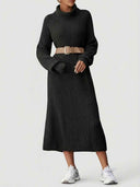 Black ribbed knit maxi dress with turtleneck and tan belt, front view.