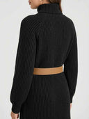 Black ribbed knit maxi dress with a tan belt, back view.