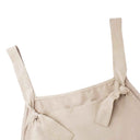 Beige jumpsuit shoulder straps tied in knots, close-up detail.