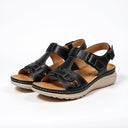 Black flatform sandals with tan cushioned footbed and white contrast topstitching, angled three-quarter view.
