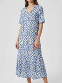 Blue and white ikat print maxi dress with V-neck, short sleeves, and tassel ties, front view.
