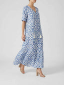 Blue and white ikat print maxi dress with V-neck and tassels, angled view.