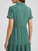 Green polka dot dress with ruffled short sleeves and tiered skirt, back view.