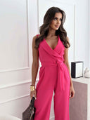 Pink sleeveless jumpsuit with wide legs, tie waist, and lapel collar, angled front view.