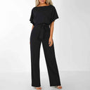 Black wide-leg jumpsuit with boat neck, short sleeves, and waist tie, front view on white background.